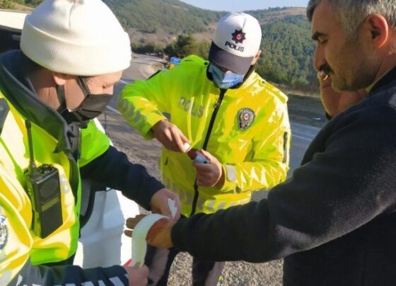 Polis devrilen tırdan çıkardığı sürücünün yaralanan elini sardı